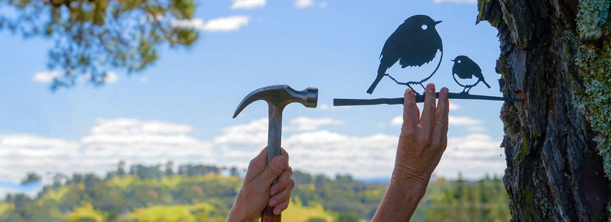 Metalbird van een roodborst wordt aan een boom gehangen