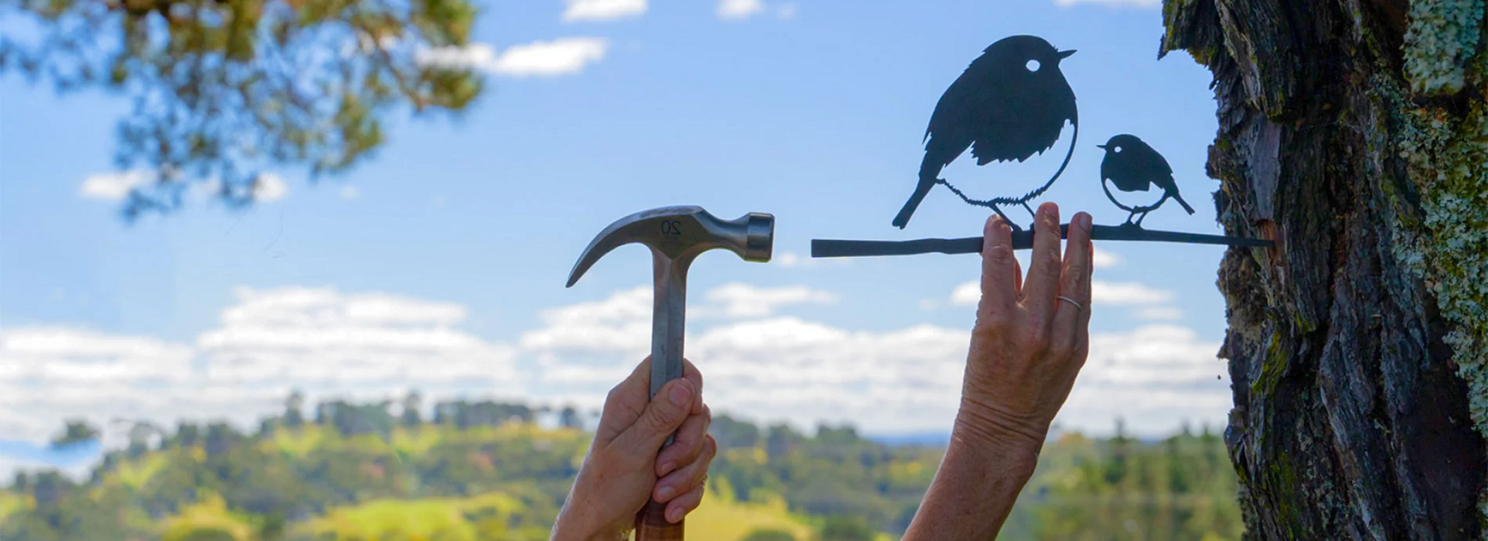 Metalbird van een roodborst wordt aan een boom gehangen